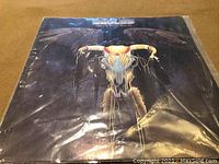 Front cover of Eagles "One of These Nights" LP vinyl album showing winged buffalo skull art.
