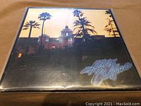 Front cover of Eagles Hotel California vinyl LP showing building with palm trees at sunset.