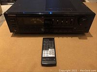 Front view of Pioneer SX-2900 stereo receiver with remote control in front showing control buttons, display, and volume knob.