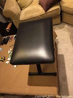 Side and top view showing the padded black vinyl seat with rectangular shape on metal adjustable base.