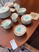 Overview of the entire 21-piece Paul Mueller Bavaria China set on table with each subset grouped showing plates, bowls, cups and saucers.