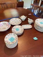 Full view of stacked china plates and serving pieces on wooden table