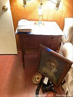 Close view of side table with two drawers and cloth-covered surface.