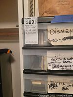 Stacked clear plastic drawers labeled and containing matchbook covers