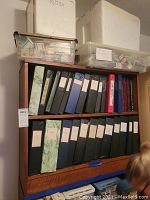 Wooden shelf unit loaded with binders and top storage containers