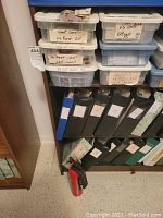 Top two shelves containing clear plastic storage containers labeled by region or hotel theme