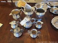 Overview of eight-piece silver plated lot including ice buckets, coffee pot, pitcher and small serving pieces