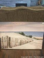Front view of the canvas art print showing the full beach scene with sand dunes and ocean under a pinkish sky.