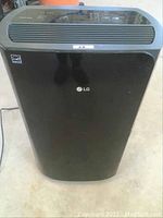 Front view of black LG PuriCare dehumidifier showing control panel and air outlet.