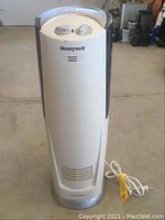 Front view of white Honeywell humidifier with control knobs and logo on front.