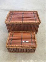 Two rectangular wood slat and rope decorative storage boxes with lids closed, showing their textured surfaces and rope borders.