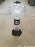 Front angle view of the Gumball Wizard Machine showing the large clear globe and black base with the quarter coin slot.