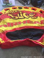 Inflatable Mega Slice tube laid flat showing bright red, black and yellow coloring and Airhead branding.