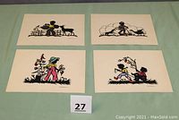Four paper cut silhouette artworks on a green surface, showing all four designs together with colors and animals including children and dogs.