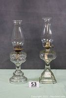 Full front view of both Peanut and Colonial kerosene oil lamps showing full lamps with chimneys and burners.