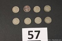 Eight Liberty Head nickels laid out on black surface, showing obverse sides with dates visible.