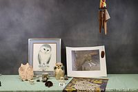 Overall lot including framed artworks, owl figurines, wind chimes, and tapestry.