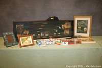 Photo showing the entire lot including shadow box, visor, retrievers, golf balls, framed prints, book, prank box.