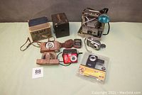 All cameras and accessories included in the lot shown together on a light green surface, showing condition and variety