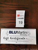 Photo of $25 gift certificate for Blu Martini Bar & Grill along with charity auction ticket number 19.