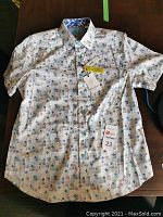 Front of the men's short sleeve dress shirt with tags showing pattern and buttons