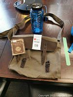 Vintage Classics haversack with leather straps, front view, showing attached hangtag and Nalgene water bottle.