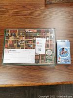 Shows the $20 Minotaur gift certificate on top of the sealed Cobble Hill 1000+ piece puzzle and the Timeline card game on the side.