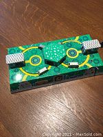 Top view of the vintage Russian tin toy train station with green base, tracks, two buildings, and two small train cars.