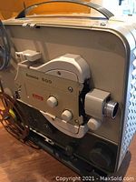 Side view of beige Kodak Brownie 500 Model C projector showing adjustment knobs and lens.