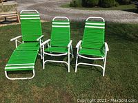 Front view of one chaise lounge and two chairs on grass