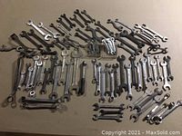 Full lot of assorted vintage wrenches laid out on a flat surface, showing variety of styles and sizes, metal finish with patina and wear.