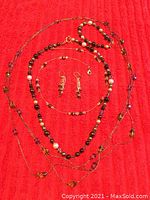 Full lot overview showing all six pieces of beaded jewelry on red background.