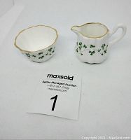 Mini creamer and sugar bowl set showing design and scale with auction tag.