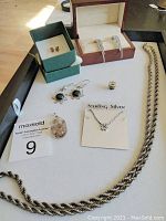 Full view of sterling and 14k jewelry laid out on tray showing all items including earrings, pendants, necklaces, and pin.