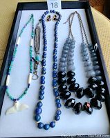 Full view of semi-precious beaded jewelry set showing various necklaces and earrings in a black tray