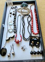 Full view of various fashion jewelry pieces arranged on white surface, including necklaces, earrings, and bracelets, showcasing style and types.