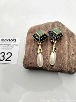 Front view of vintage Vendome clip-on earrings showing blue enamel square tops with green stones and dangling teardrop faux pearls.