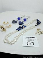 Full view showing all jewelry pieces of freshwater pearls and lapis lazuli with gold-tone floral clips, pearl drops, and ring