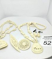 Overview photo showing two carved bone necklaces with elephant pendants, matching elephant earrings, and two carved bone brooches.