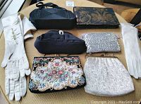 Full lot showing six purses and two pairs of gloves arranged on a table.