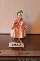 Front view of Royal Doulton Bo Peep figurine showing the woman in pink dress and green bonnet holding staff.
