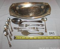 Photo showing the full collection including large Daffodil dish, various spoons, forks, salt spoon, and lifter, arranged with ruler for scale