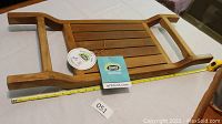 Full view of teak wood spa sauna seat or tray with slatted wood design and handles, includes original ARB label and measuring tape showing length.