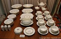 Full overview of the entire 63-piece Northumbria Morning Mist fine china dish set arranged on a table showing plates, bowls, cups, saucers, serving pieces, and condiment containers, illustrating condition and completeness.