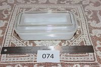Top view of rectangular white milk glass container with clear lid showing ruler for size.