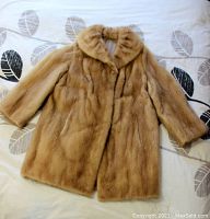 Front view of the palomino mink fur jacket showing three-quarter length sleeves, collar, front slash pockets, and overall condition.