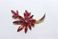 Close-up frontal view of the Sherman pink stone floral bouquet brooch highlighting the detailed stone setting and gold metal stems.