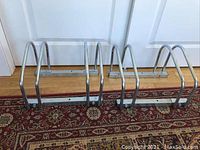 Two EasyGo metal bike stands side by side showing U-shaped slots and mounting holes.