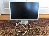 Front view of Cinema HD Display on stand with power and video cables coiled at base