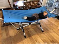 Full view of assembled hammock with frame and child lying on it